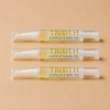Three bottles of TROOTH beauty Cuticle & Nail Oil on a beige background