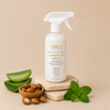 TROOTH Leave-In Milk bottle with aloe vera leaves, shea nuts, and mint leaves on a beige background
